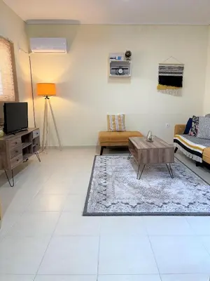 a living room with a couch and a coffee table at Boho Apartment near Athens Airport in Spáta