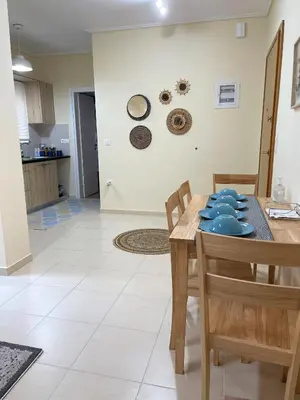 a kitchen and dining room with a table and chairs at Boho Apartment near Athens Airport in Spáta
