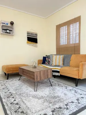 a living room with a couch and a coffee table at Boho Apartment near Athens Airport in Spáta