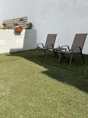 two chairs and a table sitting on a lawn at Boho Apartment near Athens Airport in Spáta