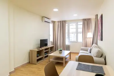 a living room with a couch and a tv at Athens Kyniska Urban Apartment in Athens