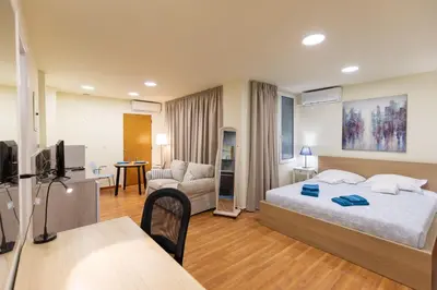 a bedroom with a bed and a living room at Athens Kyniska Studio in Athens