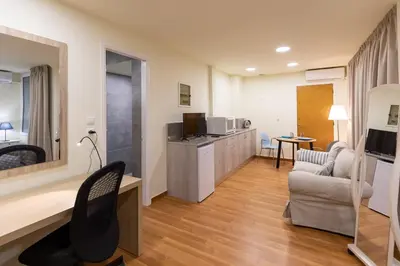 a living room with a couch a chair and a kitchen at Athens Kyniska Studio in Athens