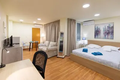 a bedroom with a bed and a living room at Athens Kyniska Studio in Athens