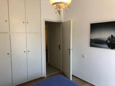 a bedroom with white cabinets and a chandelier at Metaxourgio spacious two bedroom apartment in Athens