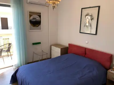a bedroom with a blue bed and a window at Metaxourgio spacious two bedroom apartment in Athens