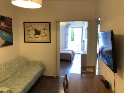 a living room with a couch and a table and a television at Metaxourgio spacious two bedroom apartment in Athens