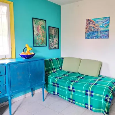 a living room with a couch and a table at Painter's house by the beach in Athens