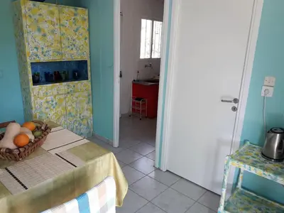 a kitchen with a table with a basket of fruit on it at Painter's house by the beach in Athens