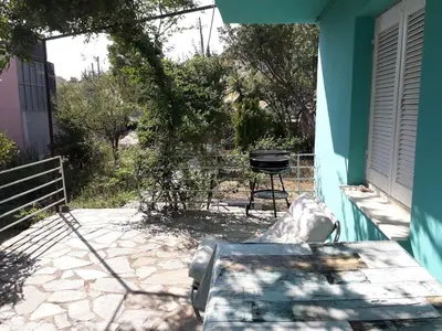 a patio with a table and a grill on a house at Painter's house by the beach in Athens