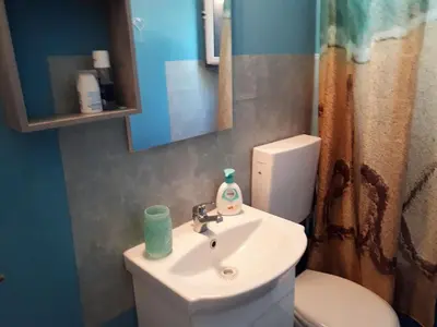 a bathroom with a sink and a toilet and a mirror at Painter's house by the beach in Athens