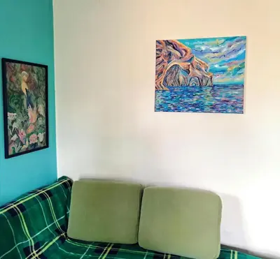 a couch in a room with a painting on the wall at Painter's house by the beach in Athens