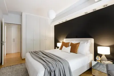 a bedroom with a large white bed with a black wall at Modern 1BD Apartment close to the Acropolis Museum by UPSTREET in Athens