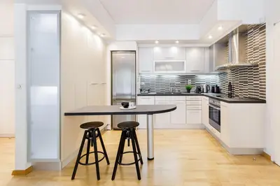 a kitchen with a table and two bar stools at Modern 1BD Apartment close to the Acropolis Museum by UPSTREET in Athens