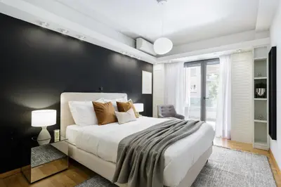 a bedroom with a white bed and a black wall at Modern 1BD Apartment close to the Acropolis Museum by UPSTREET in Athens
