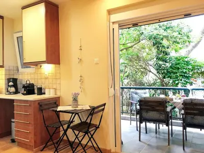a kitchen with a table and chairs and a balcony at A2 Cute Vouliagmeni Apt in a Unique Spot in Athens