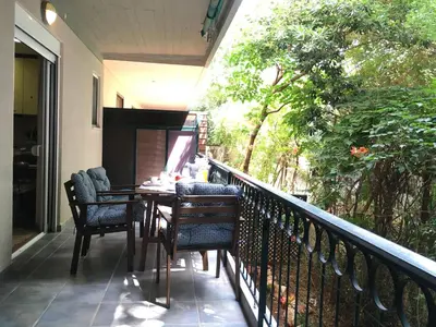 a porch with a table and chairs on a balcony at A2 Cute Vouliagmeni Apt in a Unique Spot in Athens