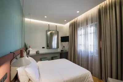 a bedroom with a white bed and a window at Ederlezi Zoubourlou Aparthotel in Athens