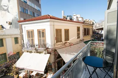 a balcony with a blue chair and a building at Ederlezi Zoubourlou Aparthotel in Athens
