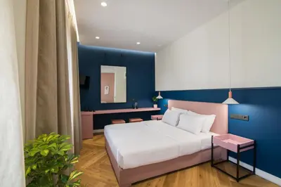 a bedroom with a bed and a blue wall at Ederlezi Zoubourlou Aparthotel in Athens