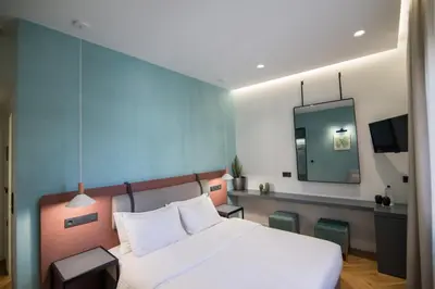 a bedroom with a white bed and a mirror at Ederlezi Zoubourlou Aparthotel in Athens