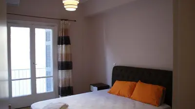 a bedroom with a bed with orange pillows and a window at The Victoria Square Exceptional Apartments in Athens