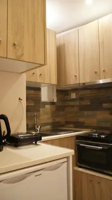 a kitchen with wooden cabinets and a stove top oven at The Victoria Square Exceptional Apartments in Athens