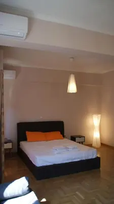 a bedroom with a large bed with an orange pillow at The Victoria Square Exceptional Apartments in Athens