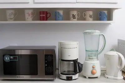 a kitchen counter with a microwave and a blender at Christina's flat in Athens