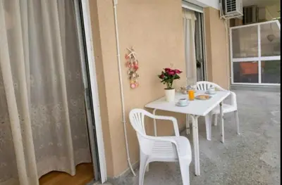 a white table with white chairs and flowers on it at Christina's flat in Athens
