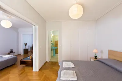 a bedroom with a bed and a living room at Christina's flat in Athens