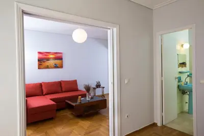 a living room with a red couch and a table at Christina's flat in Athens