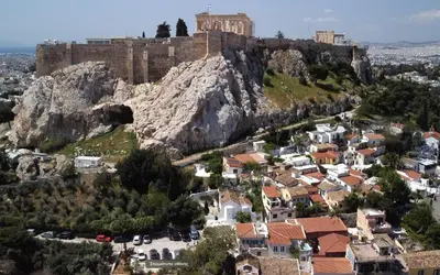 a view of a town with a castle on a mountain at In the shadow of Acropolis in Athens