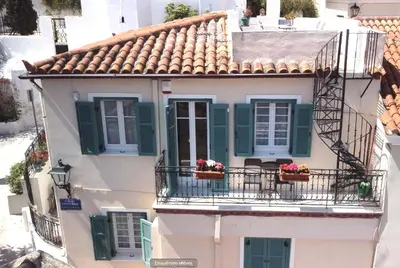 an apartment building with green shutters and flowers on the balcony at In the shadow of Acropolis in Athens