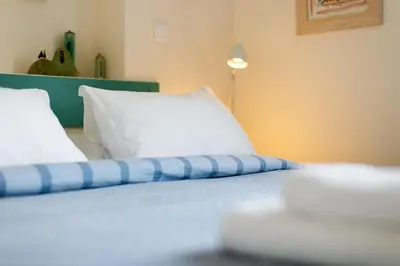 a bed with a blue and white pillow on it at In the shadow of Acropolis in Athens