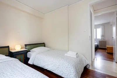 a bedroom with two beds and a room with a mirror at In the shadow of Acropolis in Athens