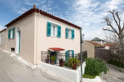 a white house with green shutters and a fence at In the shadow of Acropolis in Athens