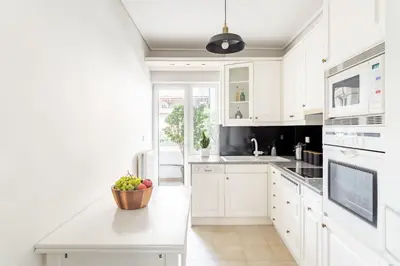 a white kitchen with a bowl of fruit on a counter at Fresh Detailed Stylish Apartment at Acropolis in Athens