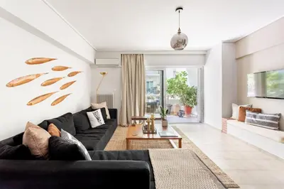a living room with a black couch and a table at Fresh Detailed Stylish Apartment at Acropolis in Athens