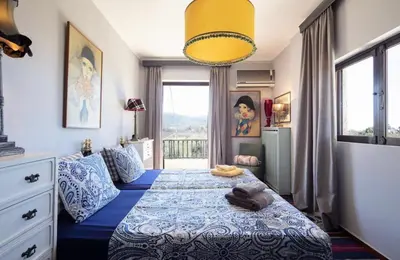 a bedroom with a bed with a blue and white blanket at Family and friendly home. in Palaiá Fókaia
