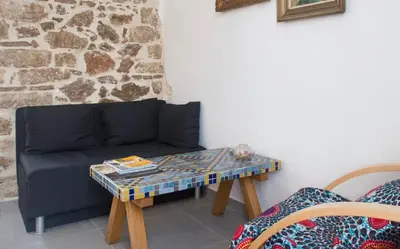 a living room with a couch and a table at A litte Taste of Home Guest House in Athens