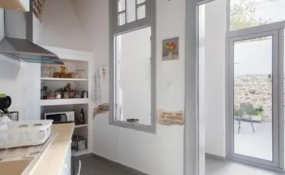 a kitchen with white walls and a window and a counter at A litte Taste of Home Guest House in Athens