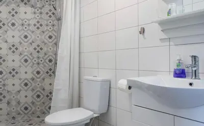 a white bathroom with a toilet and a sink at A litte Taste of Home Guest House in Athens