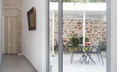a glass door leading to a patio with a table at A litte Taste of Home Guest House in Athens