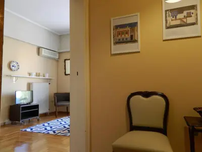 a hallway with a chair and a living room at So Athens - Charming 1BD flat, Large terrace, Acropolis view in Athens