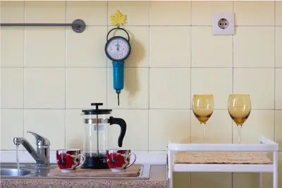 a kitchen counter with a coffee maker and two wine glasses at So Athens - Charming 1BD flat, Large terrace, Acropolis view in Athens