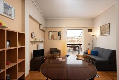 a living room with a table and a couch at So Athens - Charming 1BD flat, Large terrace, Acropolis view in Athens