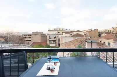 a table on a balcony with a view of a city at So Athens - Charming 1BD flat, Large terrace, Acropolis view in Athens