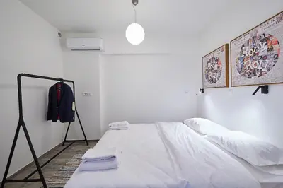 a white room with a bed and a coat rack at toStay-Unique apartment hotel in Athens center! in Athens