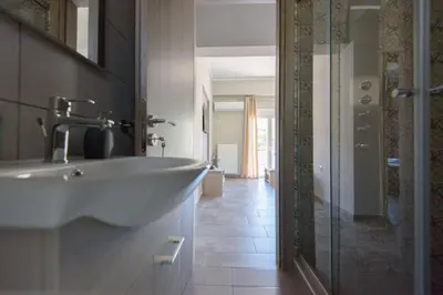 a bathroom with a sink and a glass shower at Andriana' s apartment Agia Paraskevi in Athens